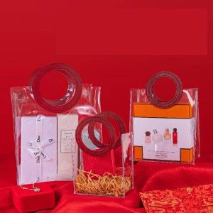 赤い円形の革ハンドルのブランクの透明で贅沢なポリ塩化ビニールのプラスチック トート バックの習慣によって印刷されるロゴの良質のギフト袋 1